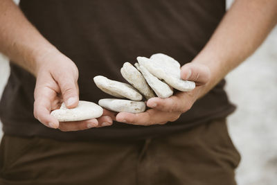 Man holding stones, mid section