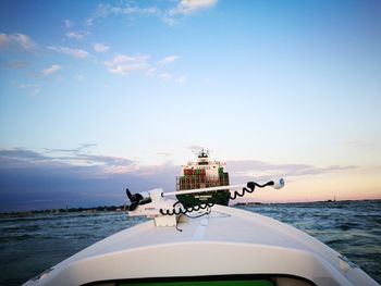 Boat on sea against sky during sunset