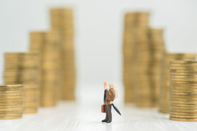 Close-up of figurines and stacked coins on table