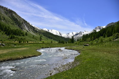 Scenic view of river amidst mountains against sky