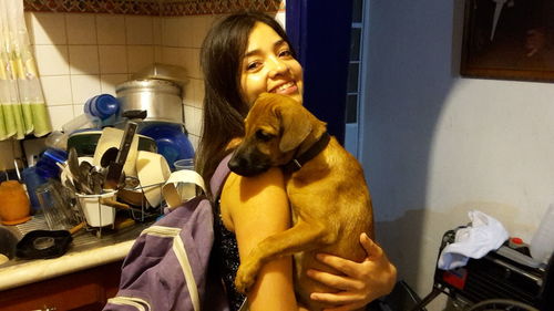 Portrait of woman with dog at home