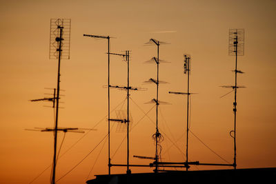 Silhouette of electricity pylon against clear sky