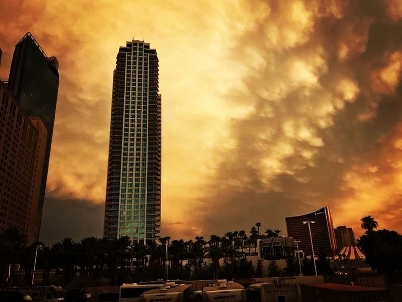 LOW ANGLE VIEW OF CITY AGAINST CLOUDY SKY DURING SUNSET