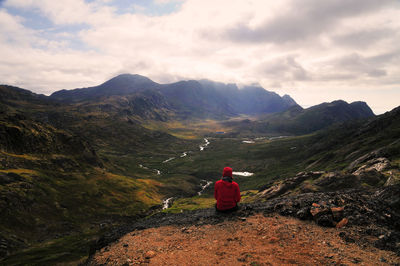 Rear view of woman standing on mountain against sky