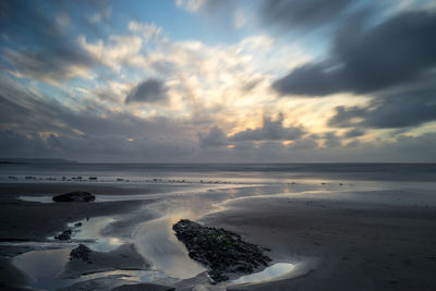 Scenic view of beach against sky during sunset
