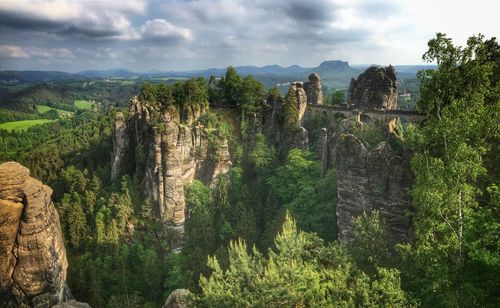 Panoramic view of trees and rocks against cloudy sky