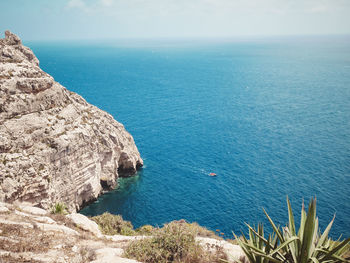 High angle view of rocks by sea against sky