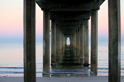 Below view of pier on shore at beach