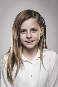 Portrait of smiling girl against gray background