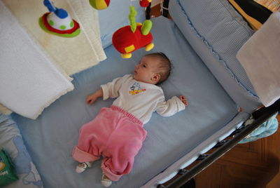 High angle view of baby lying in crib at home