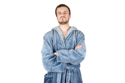 Portrait of young man standing against white background