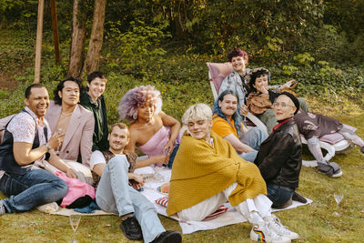 Portrait of multiracial friends from lgbtq community sitting together in back yard