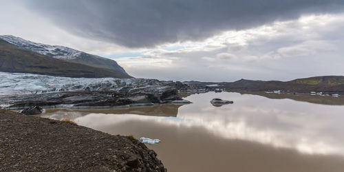 Scenic view of lake against cloudy sky