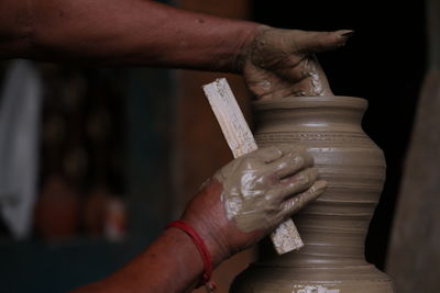 The potter works on a pottery wheel to made of soft colored clay with hand and equipment, 