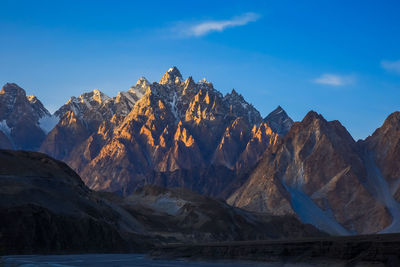 Panoramic view of snowcapped mountains against blue sky