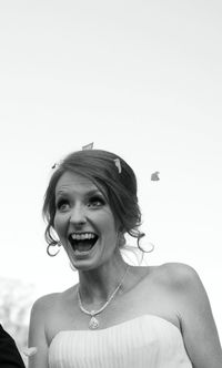 Portrait of smiling young woman against clear sky