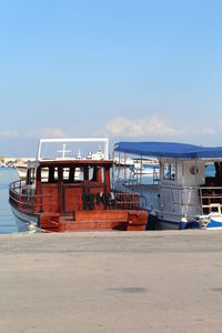 Ships moored at harbor against sky