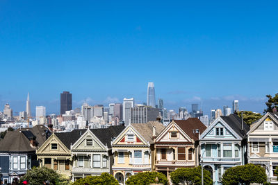 Buildings in city against blue sky