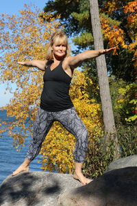 Warrior 2 yoga pose in nature by the water