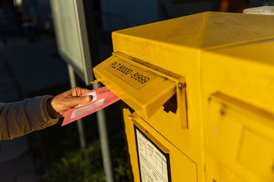 Hand holding yellow mailbox on paper