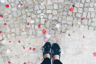 Low section of woman standing on footpath