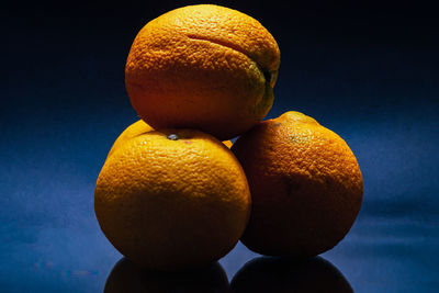 Close-up of oranges on table against black background