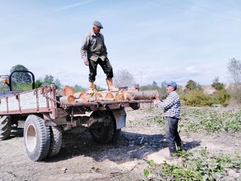 Men loading logs on truck