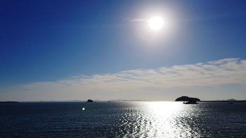 Scenic view of sea against bright sun