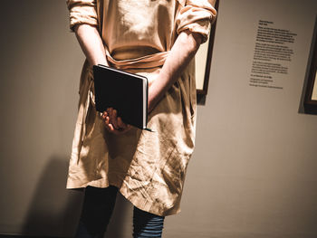 Rear view of man holding book at museum