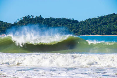 Water splashing in sea against clear sky