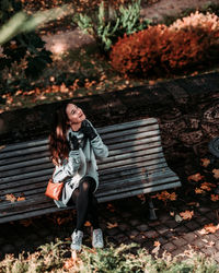 Full length of woman sitting on bench