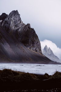 Scenic view of sea and mountains against sky