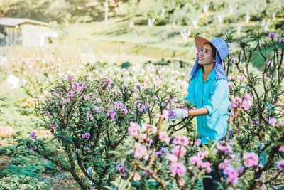 Female researcher standing amidst flowers on land