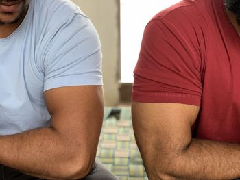 Midsection of man sitting at home