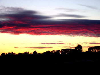 Silhouette of landscape against cloudy sky during sunset