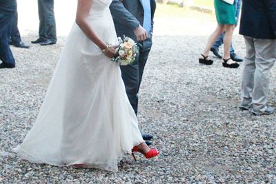 Low section of bride and groom walking on street during wedding