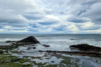 A rocky beach with bergs on iceland in strong winds with powerful surf