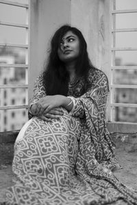 Woman looking up while sitting on terrace