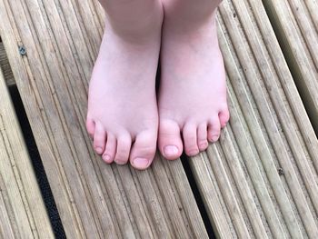 Low section of child standing on floorboard