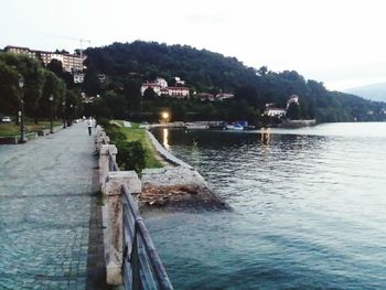 Scenic view of river by buildings against sky