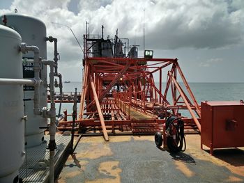 Machinery at harbor against sky