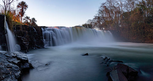 Scenic view of waterfall against sky