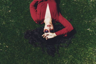 High angle view of young woman lying on grassy field