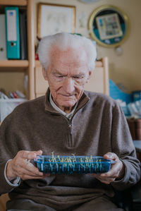 Midsection of man holding while sitting at home