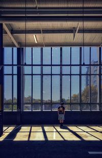 Low angle view of man gazing out of windows in building.