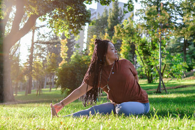 Beautiful young woman is doing yoga outside in a park. concept of healthy lifestyle.