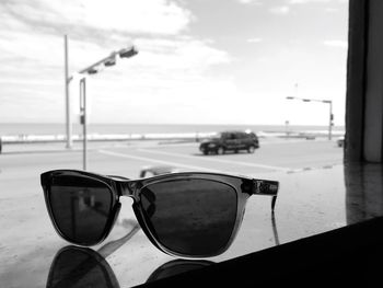 Close-up of sunglasses on beach against sky