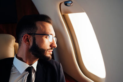 Businessman looking through airplane window
