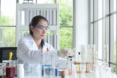Scientist working while sitting by window in laboratory