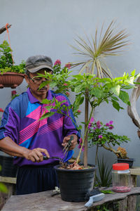 Midsection of man holding potted plant